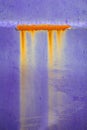 Orange rust corrosion leak from beautiful purple paint crack background, rustic decay steel metal vintage concept
