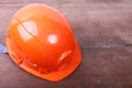 Orange safety engineer helmet on brown background