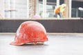 Orange safety helmet in construction with worker background.