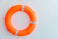 Orange safety torus or lifebuoy hanging on white wall background. Lifebuoy hanging on a cement wall.  Help and Security concept. Royalty Free Stock Photo