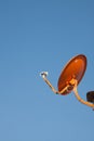 Orange satellite dish with blue sky background