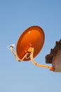 Orange satellite dish with blue sky background