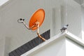 Orange satellite dish installed on the balcony of the building