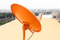 Orange satellite dish and yellow roof