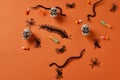 Orange seamless halloweeen background  with white skulls, black snakes, bugs and spiders and halloween candies Royalty Free Stock Photo