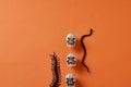 Orange seamless halloween background  with white skulls, black snakes, bugs and spiders and halloween candies Royalty Free Stock Photo