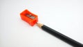 Orange sharpener and pencil isolated in light grey background. Royalty Free Stock Photo