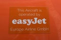 Orange sign on an easyjet airplane with the information that this airplane is operated by Easyjet Europe Airline GmbH