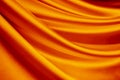 Orange silk satin curtain. Bright luxury background for design. Soft folds. Shiny golden draped fabric. Wavy lines.