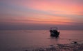 Orange skies Grey seas and a lone boat Royalty Free Stock Photo