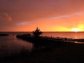 Orange sky at sunset twilight with lakeshore silhouettes after storm Royalty Free Stock Photo