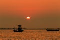 Orange sky with sunset over sea , shore and fishing boat Royalty Free Stock Photo