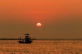 Orange sky with sunset over sea , shore and fishing boat Royalty Free Stock Photo