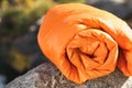 Orange sleeping bag on rock outdoors.