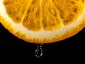 An orange, sliced and dripping with juice, indicates juiciness. Orange juice dripping from orange fruit. studio shot fruit with