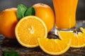 Orange sliced and orange juice glasses with green leaf on wooden table Royalty Free Stock Photo