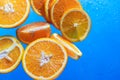 Orange slices on a blue background with water drops. The concept of proper nutrition. Royalty Free Stock Photo