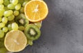 Orange slices, green grapes, kiwi, lemon slices on a gray background, fresh  fruit Royalty Free Stock Photo