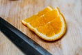 3 Orange slices and knife on a wooden table