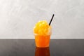 Orange Slushie in disposable plastic cup. Sweet Shaved ice. Spanish fruit granizado drink. Refreshing summer iced drink Royalty Free Stock Photo