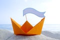 Orange Paper Boat on Sandy Seashore Close-up Small Boat from Paper on Background Royalty Free Stock Photo