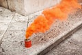 Orange smoke can on stony ground Royalty Free Stock Photo