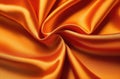 orange smooth silk fabric or satin with pleats and waves creased soft drapery material