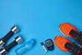 Orange sneakers, metal dumbbells, a plastic bottle with drinking water