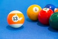 Orange snooker ball with number thirteen on table pool