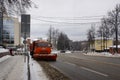 Orange snowplough Kamaz in Marshal Zhukov street of Naro-Fominsk. Cloudy winter view.