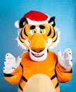 Orange soft tiger in a red santa claus hat on a blue background. Birthday and New Years 2022 concept