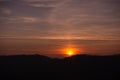 Orange solar disk seen above the forest. Wonderful sunset at the end of day