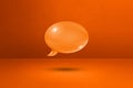 Orange speech bubble on concrete wall background Royalty Free Stock Photo