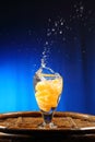 Orange splashing into glass of water Royalty Free Stock Photo