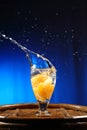 Orange splashing into glass of water Royalty Free Stock Photo