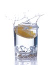 Orange splashing into glass of water on white background Royalty Free Stock Photo