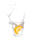 Orange splashing into glass of water on white Royalty Free Stock Photo