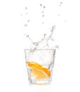 Orange splashing into glass of water on white Royalty Free Stock Photo