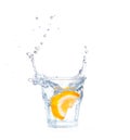 Orange splashing into glass of water on white Royalty Free Stock Photo