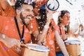 Orange sport fans screaming while supporting their team out of the stadium - Football supporters having fun at competion event - Royalty Free Stock Photo