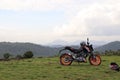 An orange sports motor bike resting on a green hill Royalty Free Stock Photo