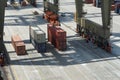 Orange spreader of gantry crane operated by stevedores approaching container on shore. Royalty Free Stock Photo