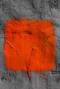 Orange square with peeling paint on gray plastered wall background. Grunge texture. copy space