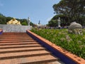 Orange stairs and many various large buddhas. Quinta dos Loridos, Portugal. Royalty Free Stock Photo