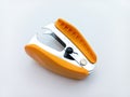 Orange Staple Remover Isolated On White Background. Tilted View From Above