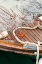 Orange starfish lies on a wooden deck of a boat near a rope and a fishing net. Close up Royalty Free Stock Photo