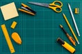 Orange stationery office supplies on green cutting mat, flat lay picture Royalty Free Stock Photo