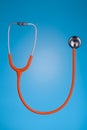 Orange stethoscope on blue background Royalty Free Stock Photo
