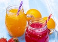 Orange and strawberry juice on blue wooden table Royalty Free Stock Photo