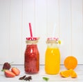 Orange and strawberry juice in a glass jar, on a white background. Royalty Free Stock Photo